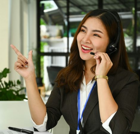 Friendly female call center agent wearing headset operating helpdesk for customer.