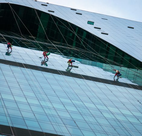 Group of industrial climbers washing glass office building facade, Moscow, 28.07.2020