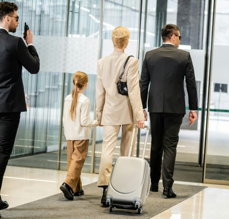 personal protection, bodyguard communicating through walking talkie and escorting blonde woman and