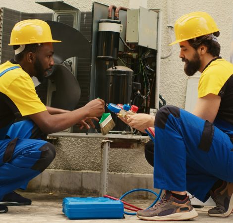 Technicians servicing HVAC system